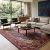 Luminous contemporary living room with a beige sofa and glass coffee table, anchored by a 7x10 red and navy Tabriz Persian rug on light wood floors.