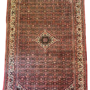 Full view of a 6' 7" x 10' 0" hand-knotted Persian Hoseinabad wool rug with an intricate diamond medallion and traditional red and cream patterned borders.