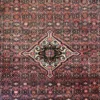 Close-up of the central medallion and dense wool pile texture on a hand-knotted Persian Hoseinabad area rug.