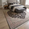 Hand-knotted Heriz Persian rug styled under an upholstered bed with a grey end-of-bed bench in a modern bedroom.