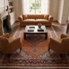 6' 9" x 10' 2" Persian Mahi wool rug styled in a luxury living room under a dark wood coffee table and caramel leather sofa.