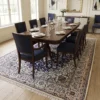 Elegant navy and cream Persian Nain wool rug under a mahogany dining table with blue upholstered chairs and a crystal chandelier.