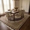 6' 5" x 9' 10" Persian Mahi wool area rug under a dark wood dining table with six cream upholstered chairs.