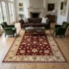 Traditional Afghan Chobi wool rug styled in a grand living room under a glass coffee table between a leather sofa and green armchairs.