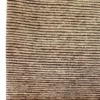 Close-up of the thick hand-spun wool pile and horizontal ribbed texture on a tan Afghan Gabbeh rug.