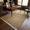Afghan Gabbeh wool carpet styled in a classic executive study under a mahogany desk and leather chair with dark wood paneling.