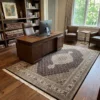 6' 9" x 10' 2" India Mahi wool rug in an executive home office under a walnut desk and leather chairs.