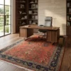 Terracotta Indian Sarough design wool carpet styled in a modern executive office under a walnut desk and leather chair.