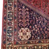 Detailed corner view of a Persian Abadeh wool rug showing the dark navy spandrel with tree-of-life motif, geometric border bands, and white fringe.