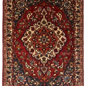 Full overhead view of a 7' 1" x 9' 7" hand-knotted Persian Bakhtiar wool rug featuring a large scalloped cream and rust medallion on a deep crimson field.