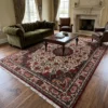 Hand-knotted Persian Bijar rug 6' 9" x 10' 1" styled in a spacious living room under a wood coffee table with an olive green Chesterfield sofa.