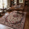 Persian Bijar area rug 6' 9" x 10' 1" in an executive home office under a dark wood desk and leather chair with built-in bookshelves.