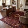 Hand-knotted Persian Hoseinabad area rug in an executive home office under a modern desk and plush armchairs.