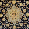 Close-up of the radial floral medallion, palmette vines, and fine wool pile on a navy blue Persian Najafabad rug.