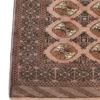 Detailed corner view of a Persian Turkaman wool rug showing geometric border bands, octagonal guls, and fringe.