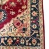 Detailed corner view of an Afghan Kazak wool rug showing the dark blue geometric floral border and ivory corner spandrel