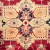 Close-up of the stepped ivory and gold geometric medallion and plush hand-spun wool pile on a red Afghan Kazak rug
