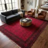 7' 0" x 10' 0" Afghan Torkman wool rug styled in a modern spacious living room under a round brass coffee table, charcoal sofa, and leather armchairs.