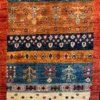 Close-up of horizontal saffron, navy, and cream bands featuring tree-of-life motifs and plush wool pile on an Afghan Uzbek runner rug