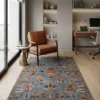 Denim blue Afghan Uzbek wool rug placed beside a cognac leather armchair and walnut desk in an executive home office.