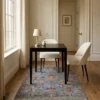 Hand-knotted Afghan Uzbek area rug styled beneath a square dark wood bistro table and two cream upholstered chairs.