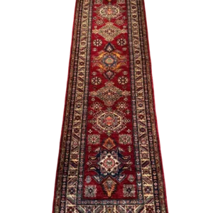Full overhead view of a 2' 6" x 10' 0" hand-knotted Afghan Kazak wool runner rug featuring a vertical sequence of geometric diamond and octagonal tribal medallions on a rich crimson red field.