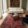 5' 0" x 7' 0" Afghan Torkman wool rug styled in a modern bright living room under a round wooden coffee table with a cream sofa and navy armchair.
