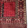 Detailed corner view of an Afghan Torkman wool rug showing the serrated diamond trellis border, square meander guard stripes, and kilim end skirt.