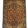Full overhead view of a 4' 3" x 6' 6" hand-knotted Persian Isfahan wool and silk rug with a cognac medallion, midnight blue floral field, and turquoise-blue Shah Abbas border.