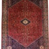 Full overhead view of a 6' 7" x 10' 3" hand-knotted Persian Abadeh wool rug featuring a large hexagonal red field with a central diamond medallion, dark blue spandrels, and bird motifs.