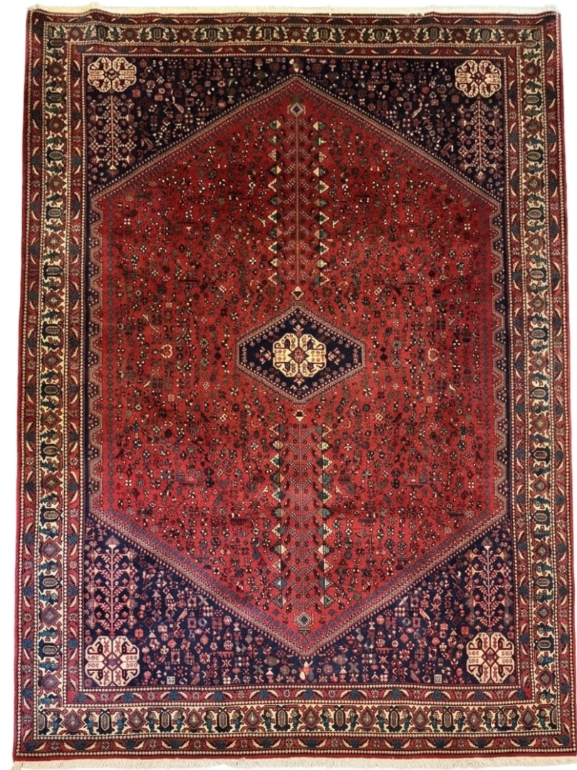 Full overhead view of a 6' 7" x 10' 3" hand-knotted Persian Abadeh wool rug featuring a large hexagonal red field with a central diamond medallion, dark blue spandrels, and bird motifs.