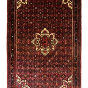 Full overhead view of a 6' 8" x 10' 4" hand-knotted Persian Hoseinabad wool rug with an eight-point geometric star medallion on a rich crimson red field.