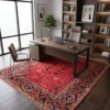 Large red Afghan Bakhtiar wool rug placed beneath a modern walnut executive desk and leather chair in a private study with illuminated bookshelves.