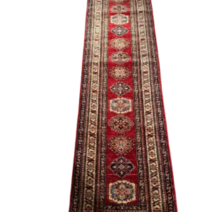 Full overhead view of a 2' 6" x 10' 0" hand-knotted Afghan Kazak wool runner rug featuring a vertical row of geometric tribal medallions in blue, gold, and ivory on a rich crimson red field.