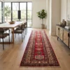 Red Afghan Kazak wool runner rug styled along a wide oak corridor between an open-concept dining table and a cane credenza.