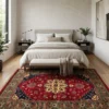 Afghan Kazak wool rug laid at the foot of an upholstered bed with a neutral bench in a serene, sunlit bedroom suite.