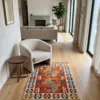 3' 0" x 4' 0" Afghan Kilim wool rug styled in a modern living room walkway beside a cream bouclé tub chair and round wood side table.